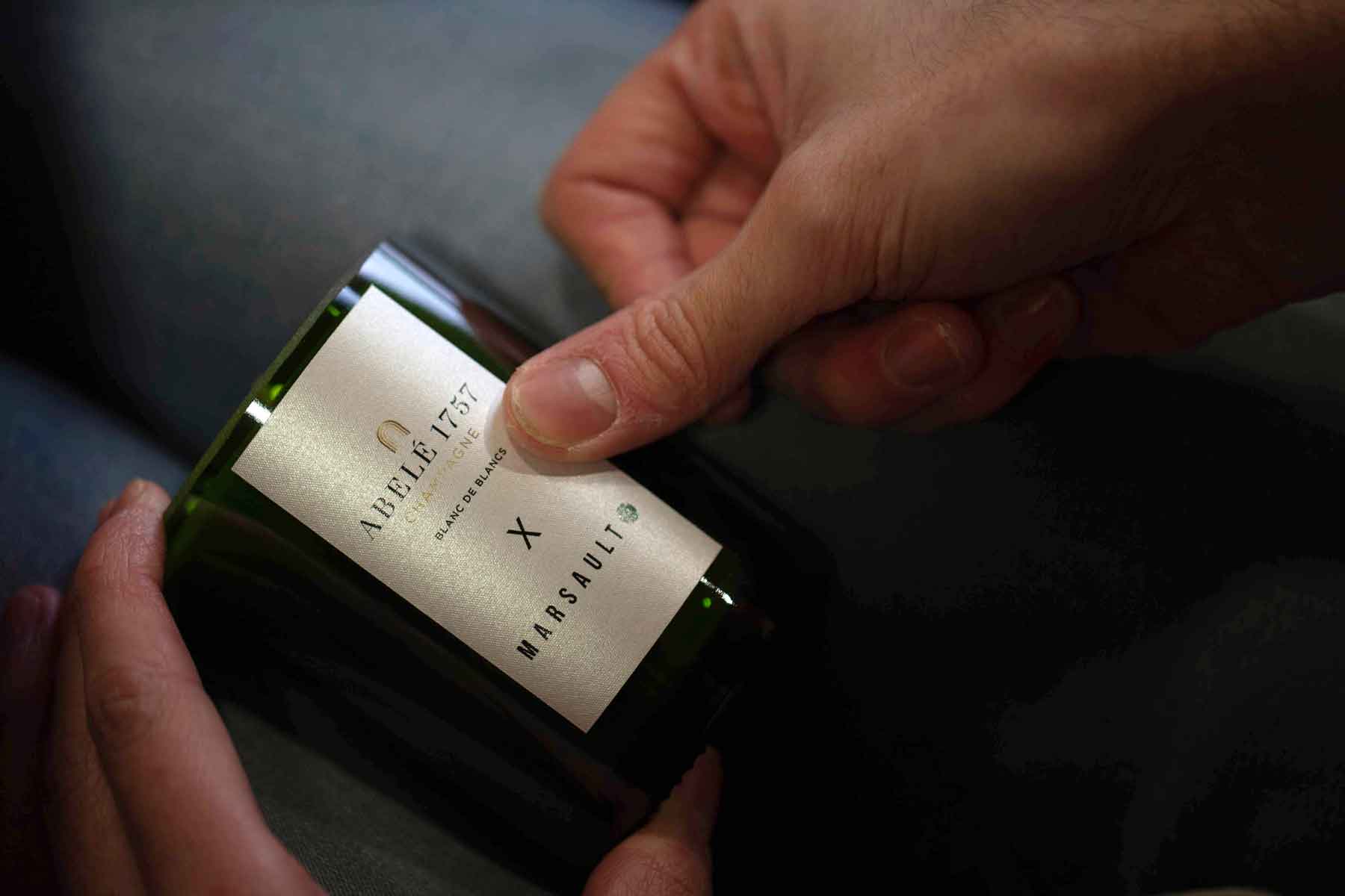 Pose de l'étiquette pour la bougie artisanale Blanc de Blancs Abelé 1757 par Marsault